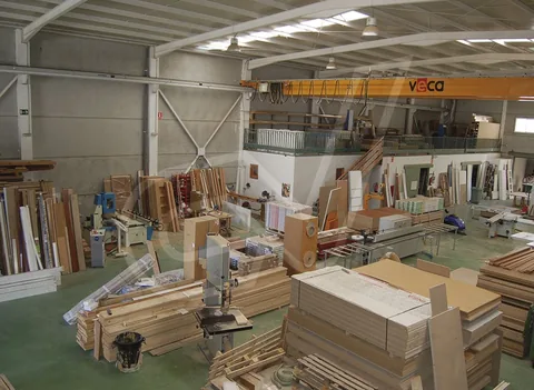 Interior de la nave con tableros y piezas en proceso de fabricación