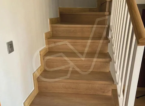 Escalera de madera con barandilla de balaustres blancos